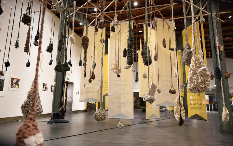Das Häkeln von Taschen gibt mexikanischen Frauen einen Zugang zu ihrer Erfahrung einer der Sterilisation – und die Fragen auf Stoffbahnen empfangen Ausstellungsbesuchende einnehmend. (Foto: Thomas Batschelet)